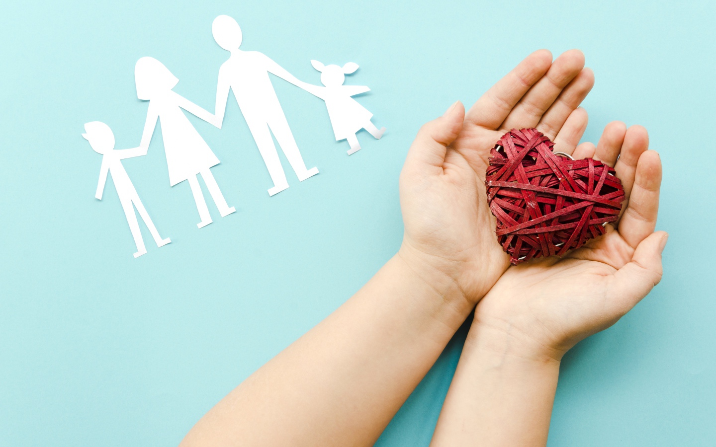 Плетеное сердце в руках на голубом фоне