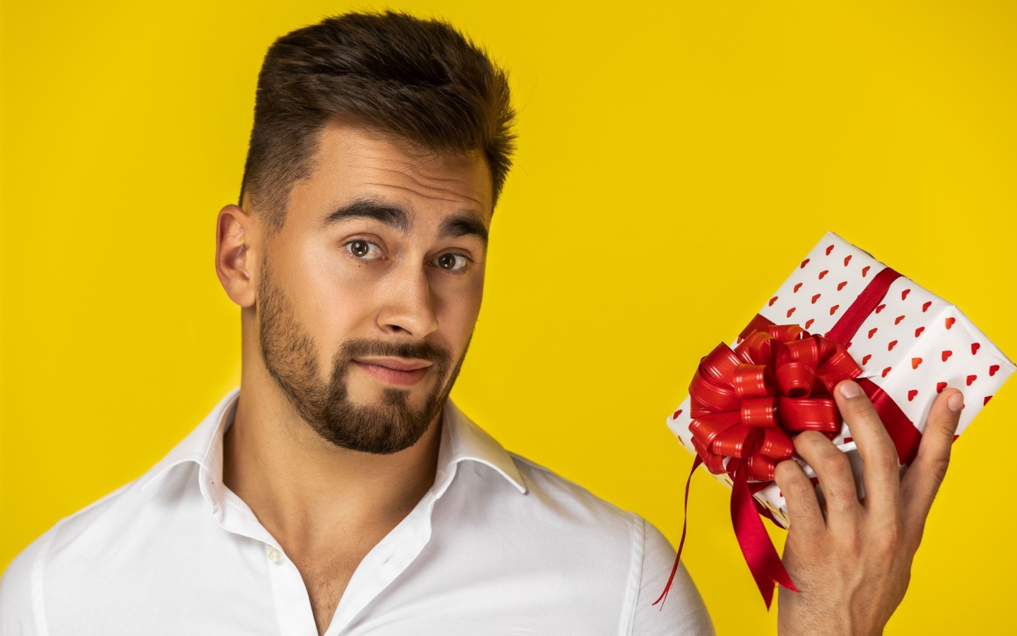 Мужчина с подарком на желтом фоне 