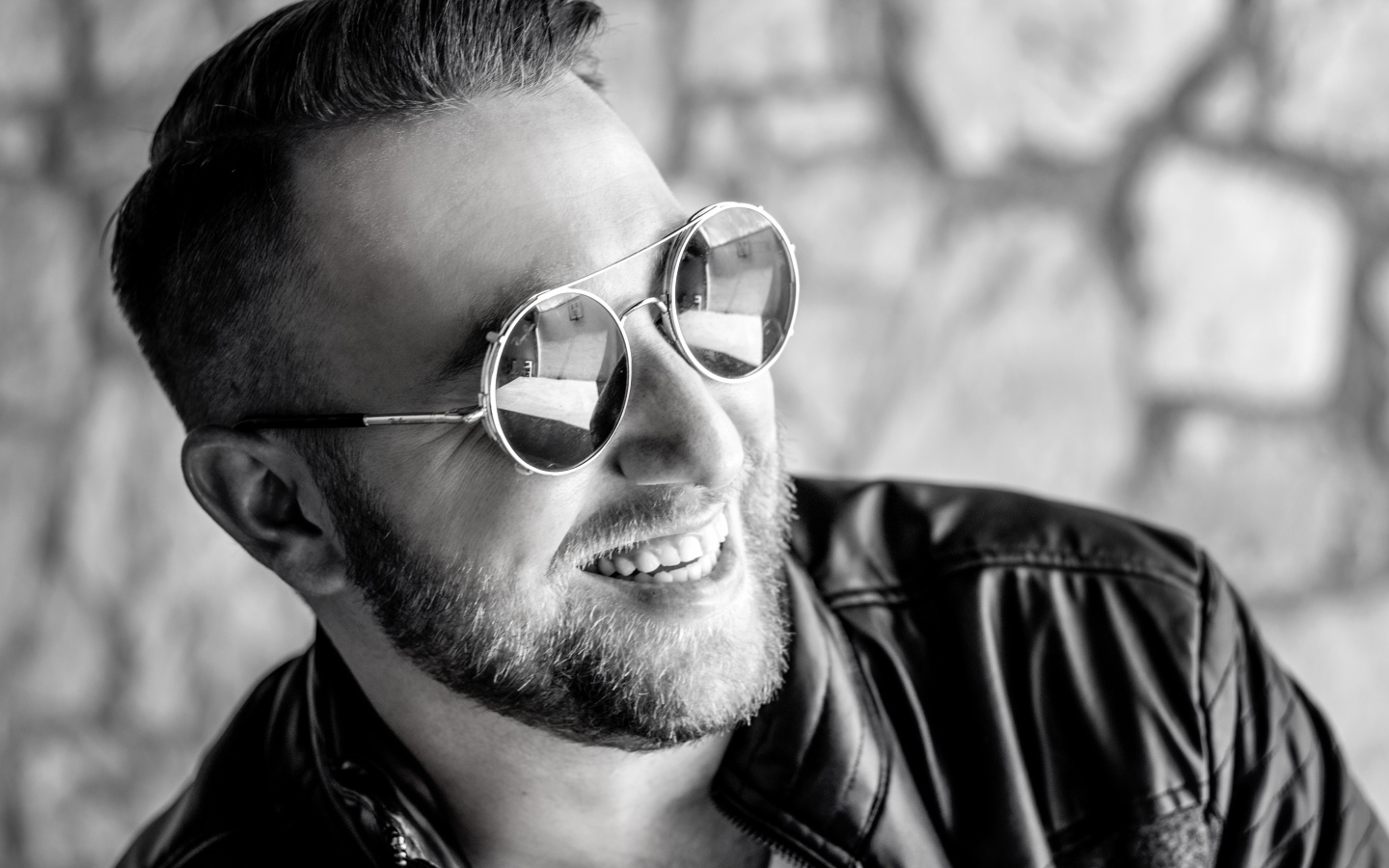 Улыбающийся брутальный мужчина в черных очках