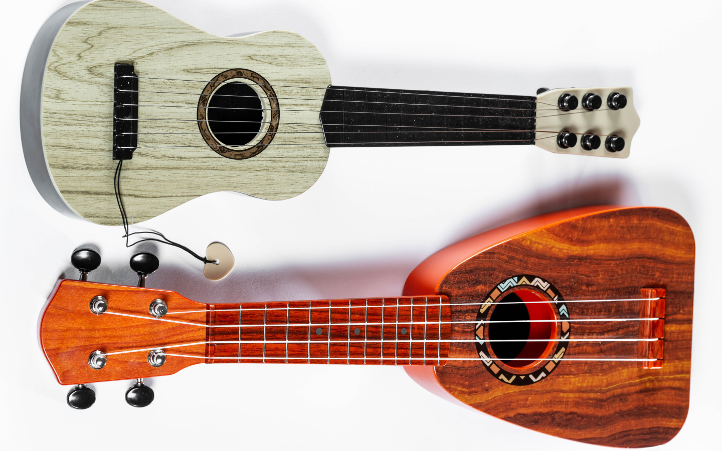 Две маленькие гитары укулеле на белом фоне