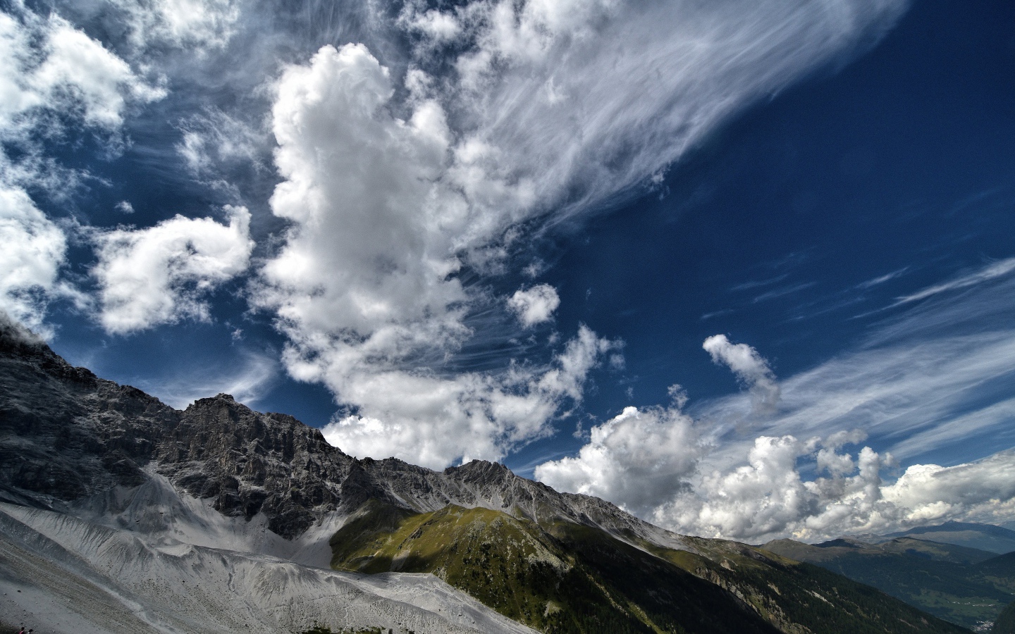 Белые густые облака в голубом небе над горами 