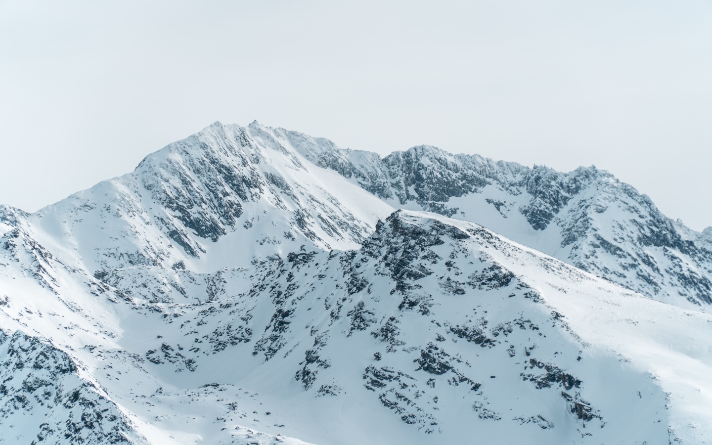 Заснеженная гора под серым небом 