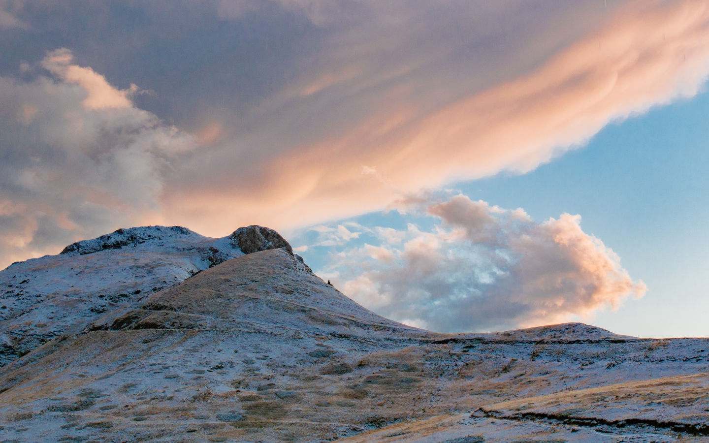 Красивые серые облака над заснеженной горой 