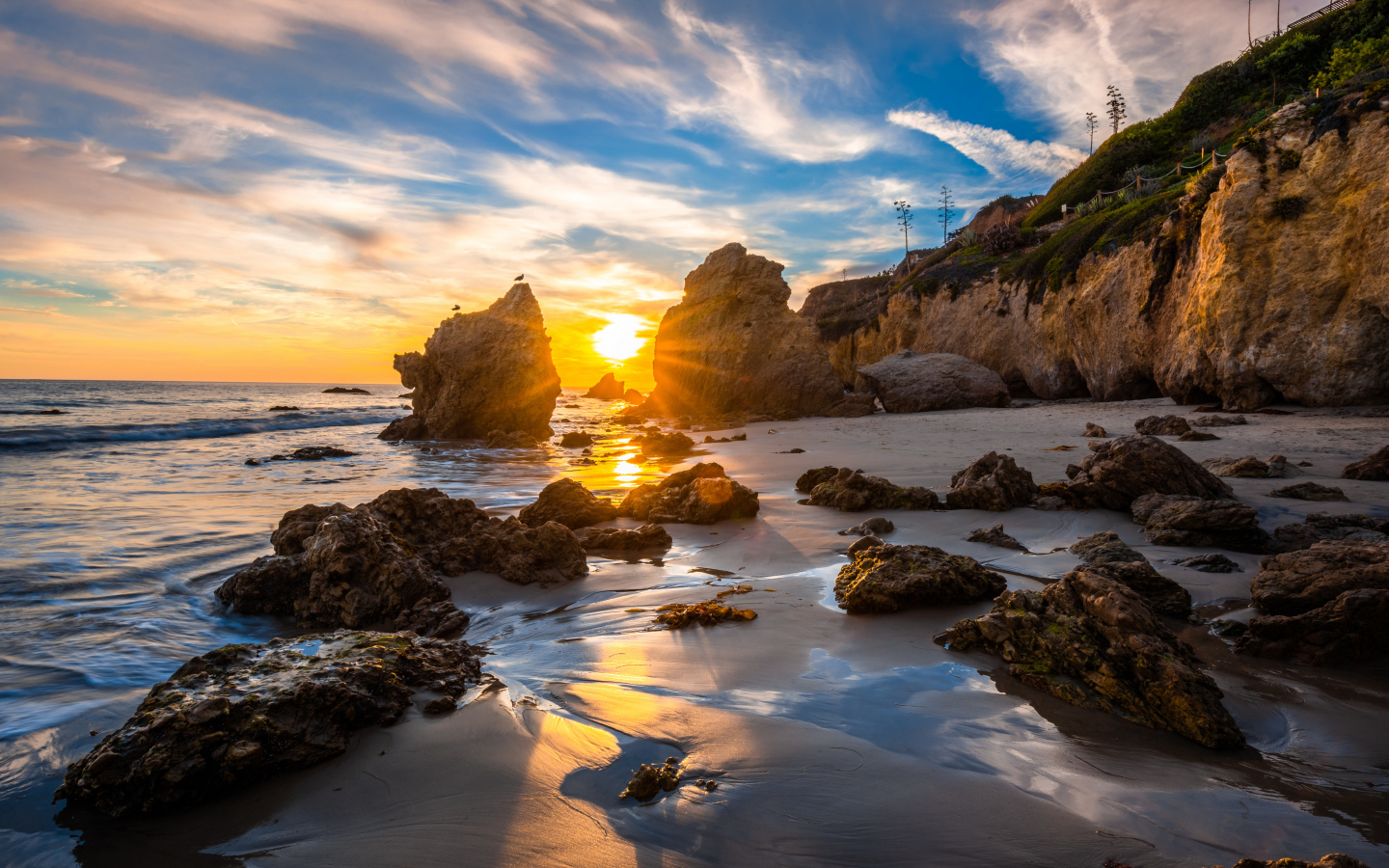 Яркий рассвет летнего солнца над скалами и океана