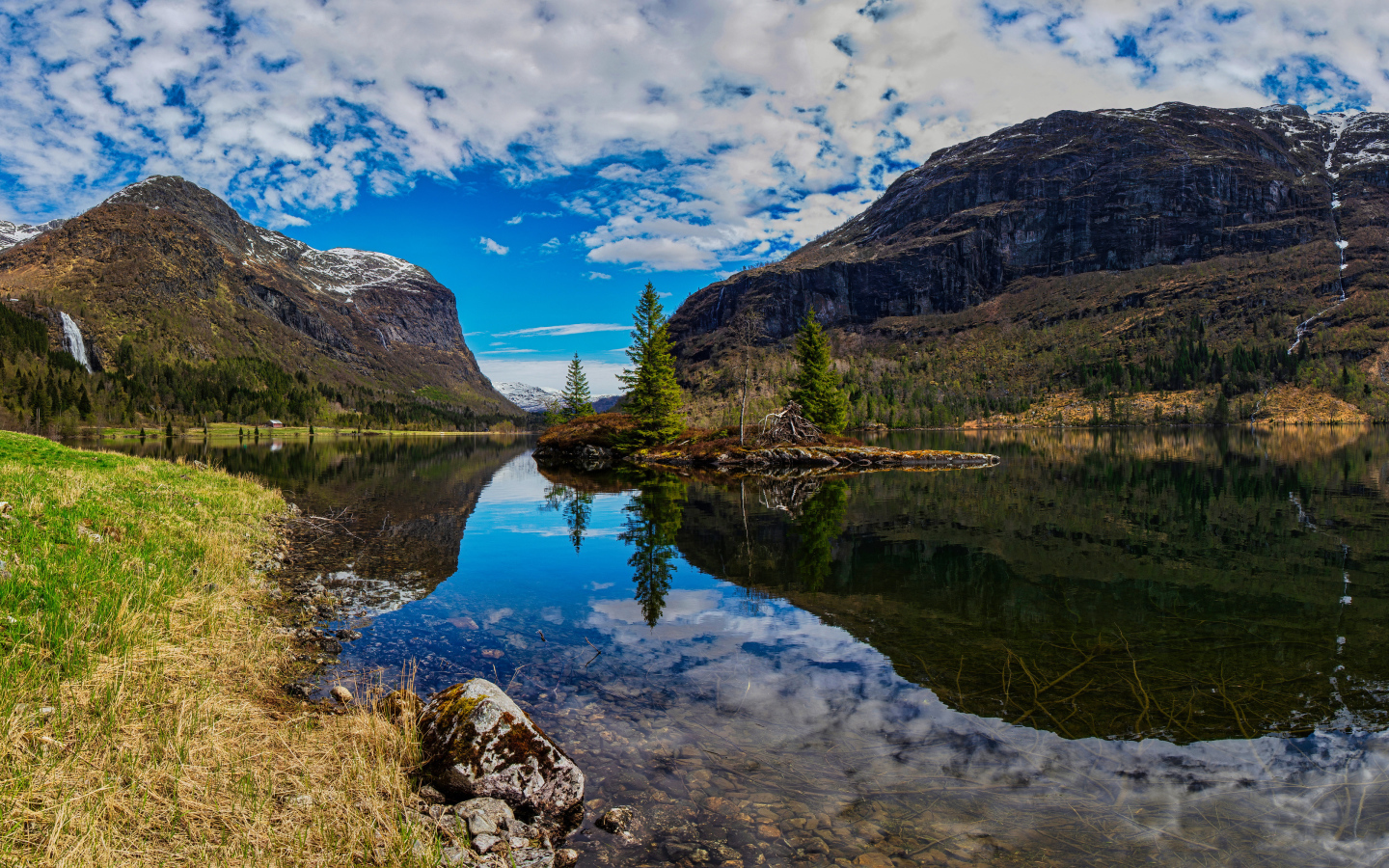 Остров среди озера у гор под красивым небом 
