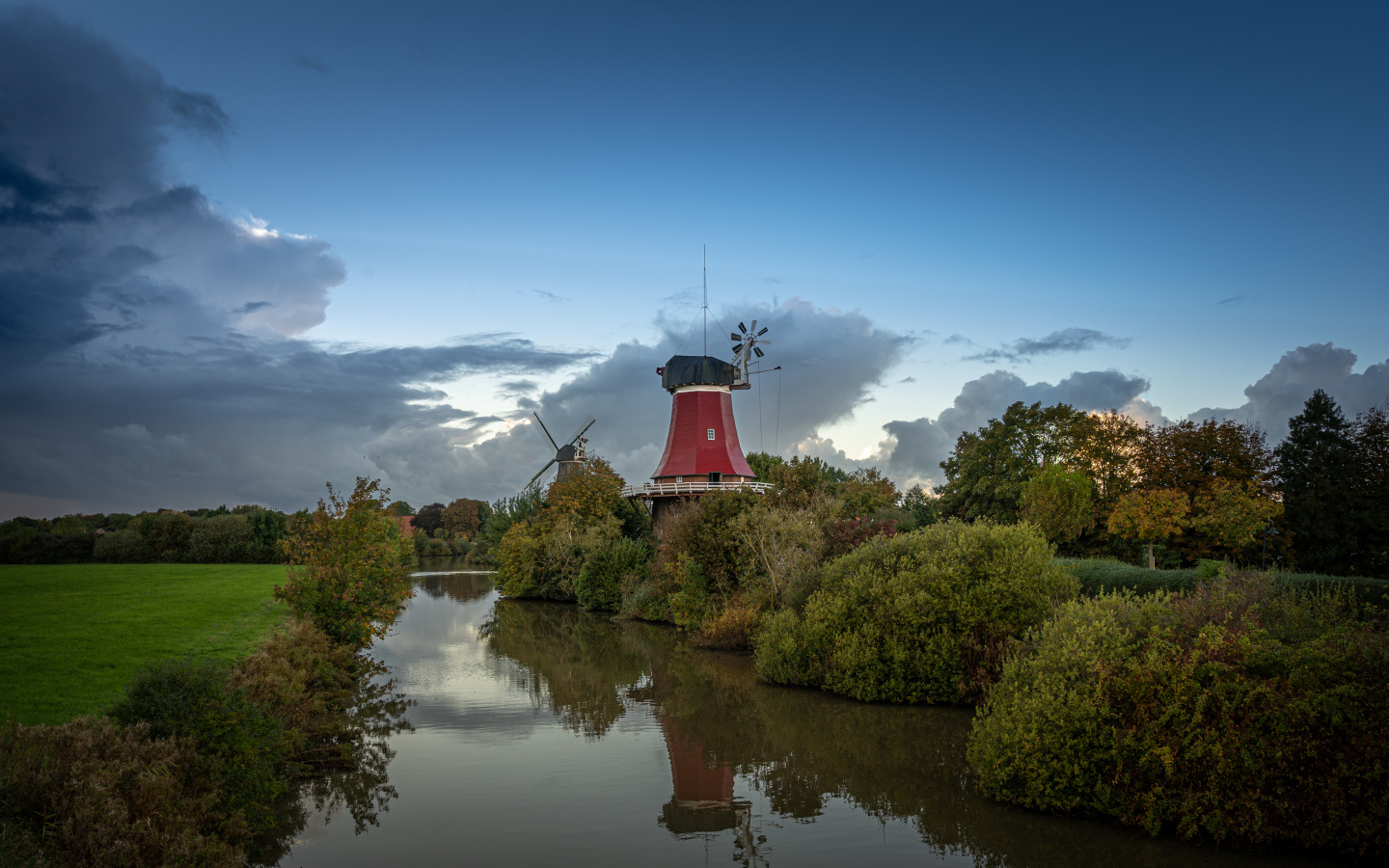 Мельница на берегу реки под красивым небом в сумерках