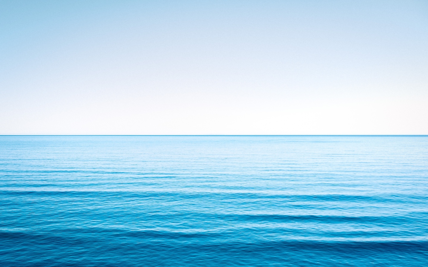 Спокойная голубая морская вода под голубым небом 