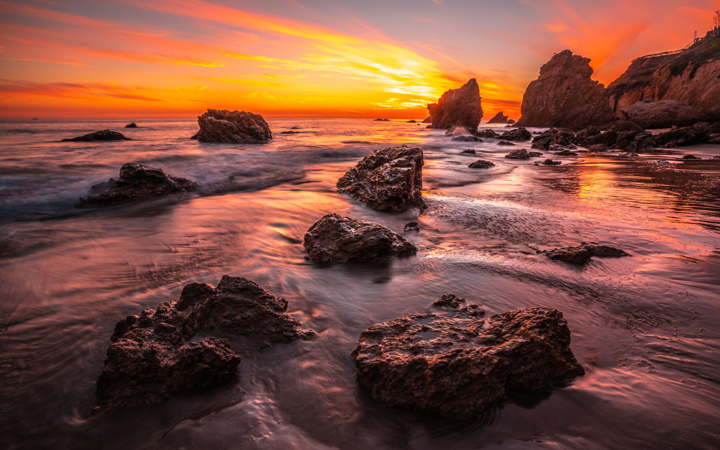 Красивый закат солнца на берегу моря с камнями 