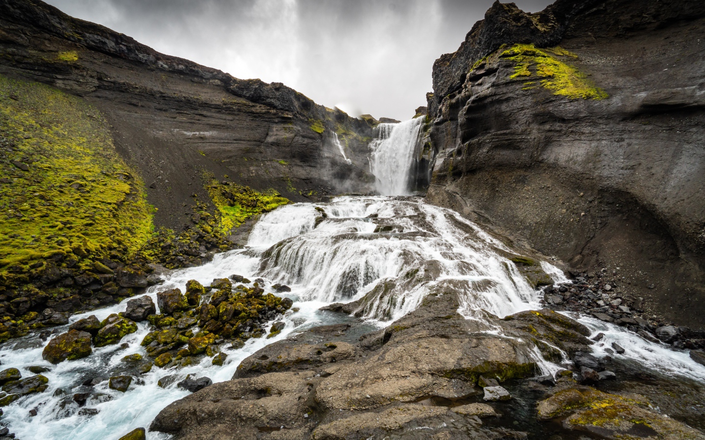 Быстрый горный водопад под серым небом