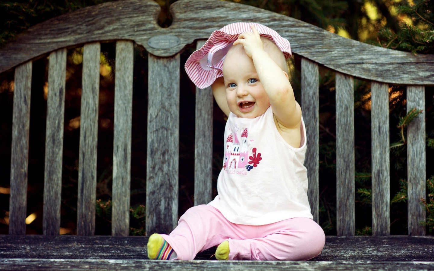 Смешной маленький ребенок сидит на лавке