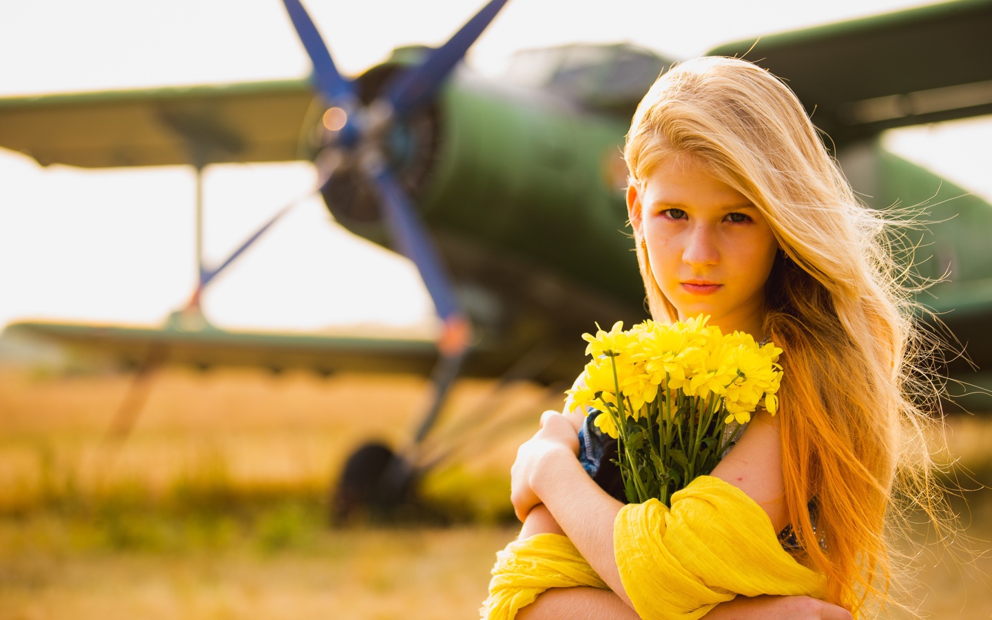 Девочка с букетом желтых хризантем у самолета 