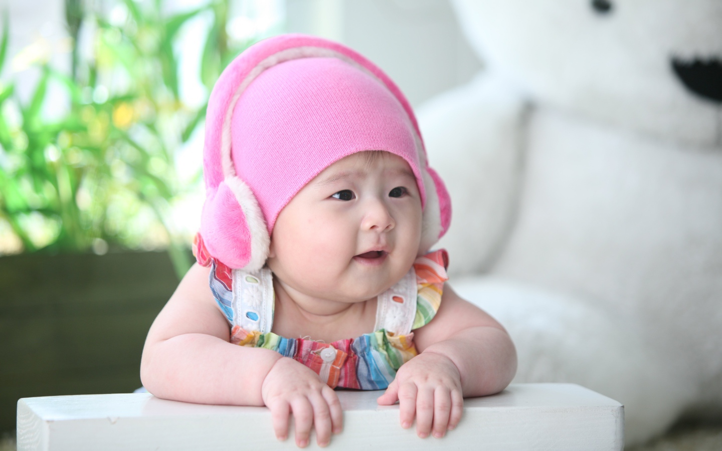 Маленький ребенок азиат в розовой шапке 