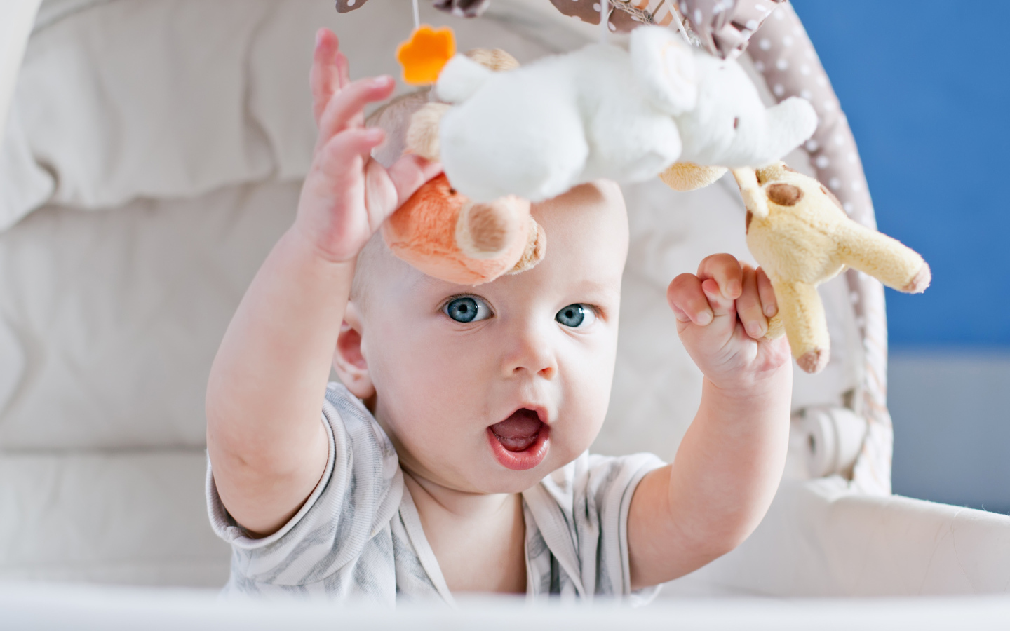 Маленький грудной ребенок в коляске с игрушками 