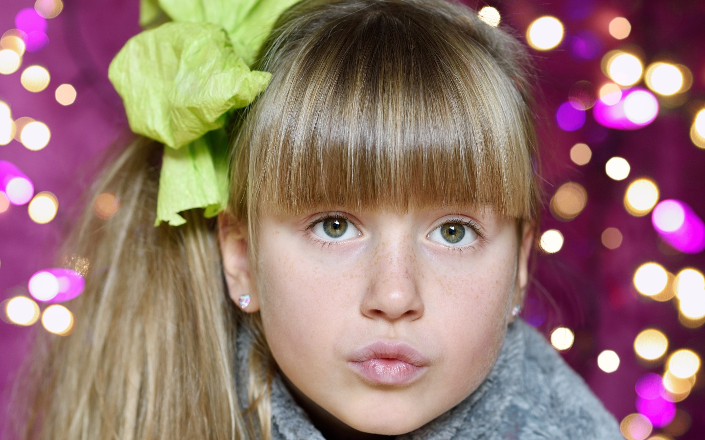 Лицо зеленоглазой девушки с бантом на голове 