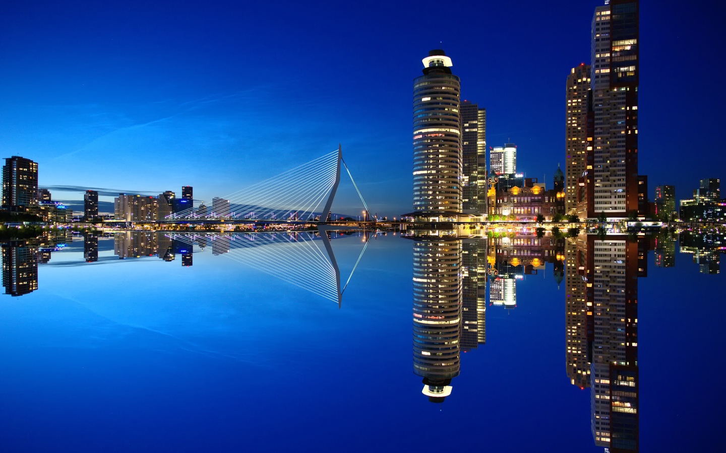 Небоскребы и мост отражаются в тихой воде
