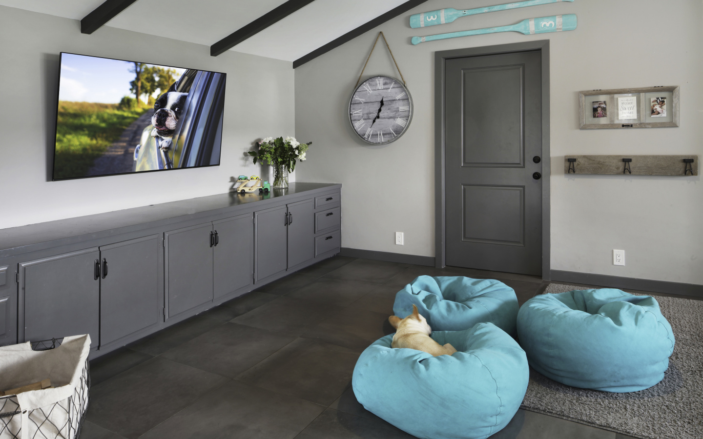 Голубые кресла в комнате с большим телевизором 