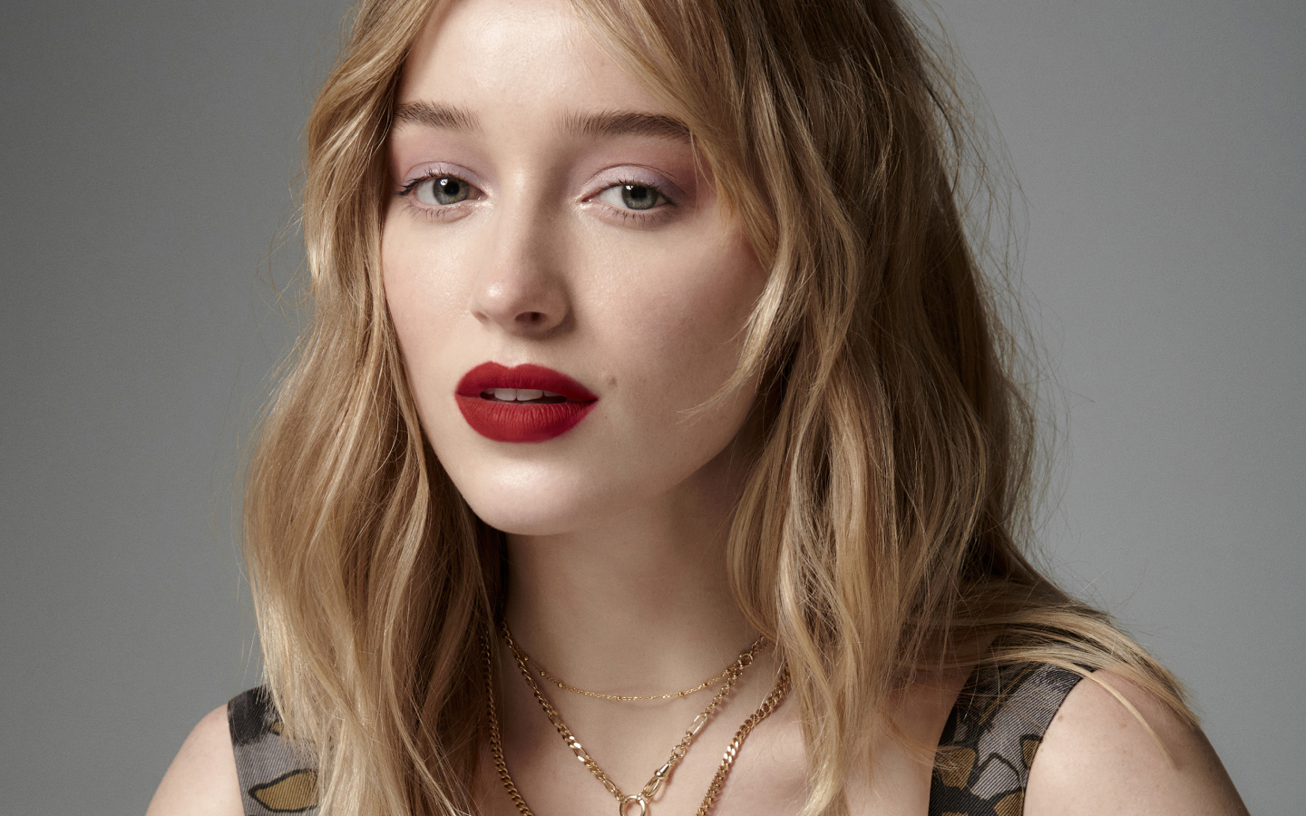 Яркая помада на губах актрисы Фиби Дайневор на сером фоне