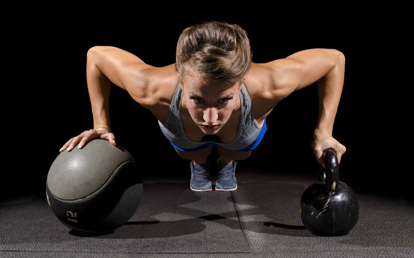 Девушка отжимается с гирями