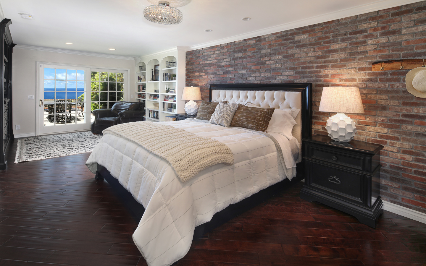 Большая кровать с белым покрывалом в спальне у окна