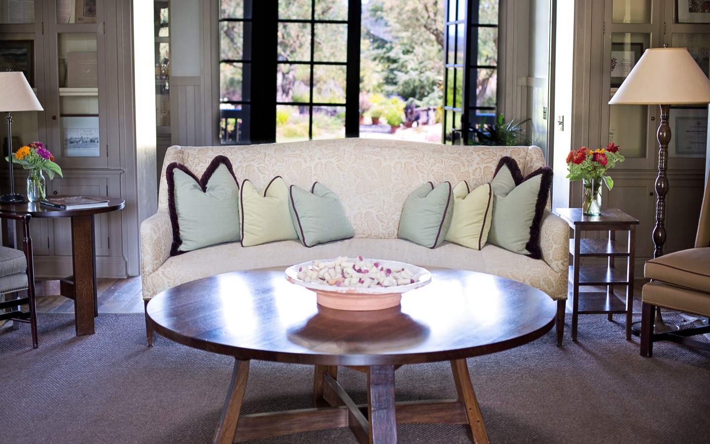 Большой диван с подушками в комнате с круглым столом 