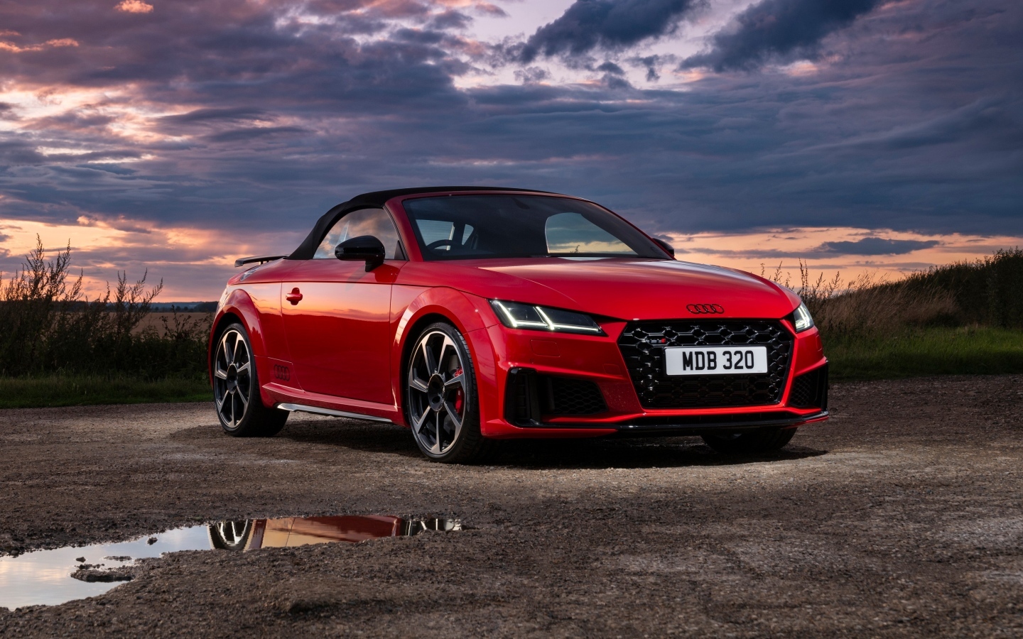 Красный автомобиль Audi TTS Final Edition Roadster 2023 года на фоне неба