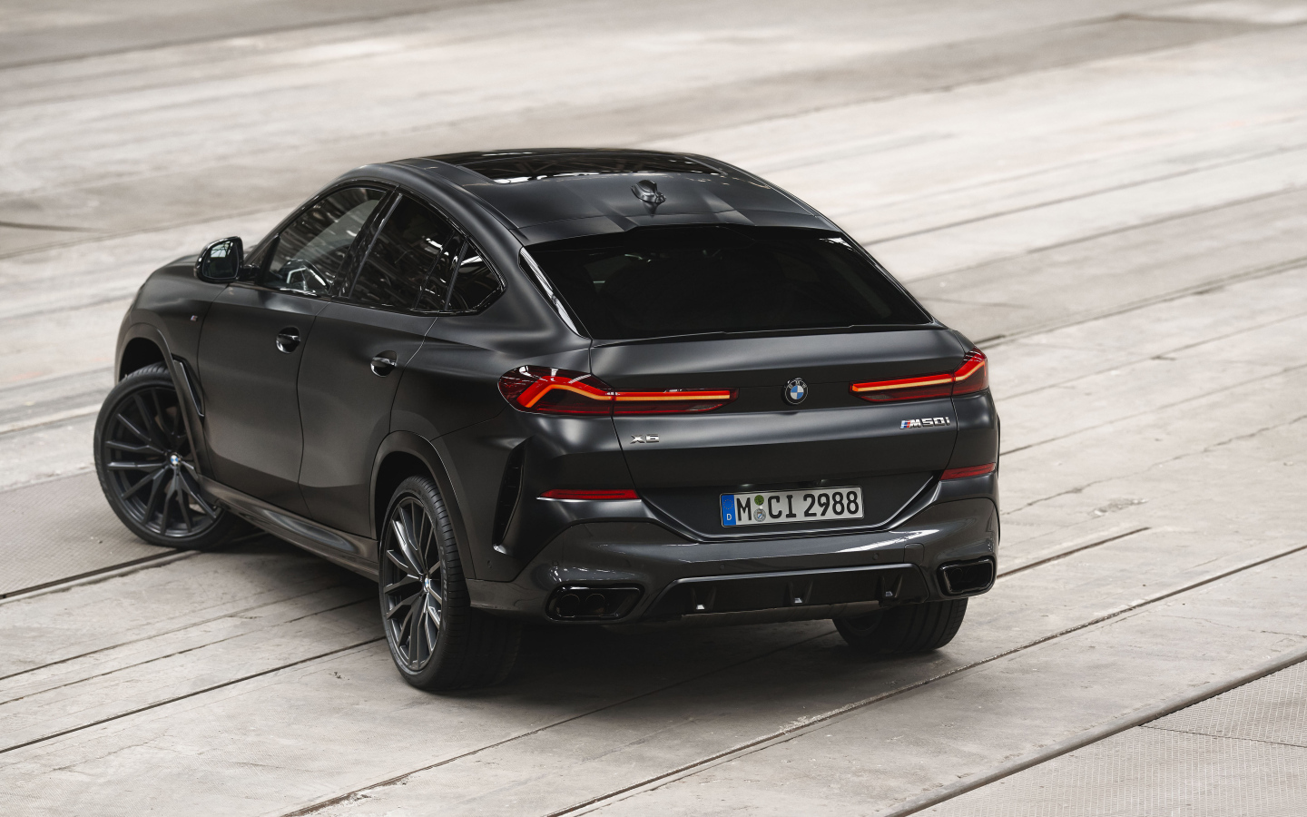 Стильный черный автомобиль BMW X6 M50i, 2023 года вид сзади