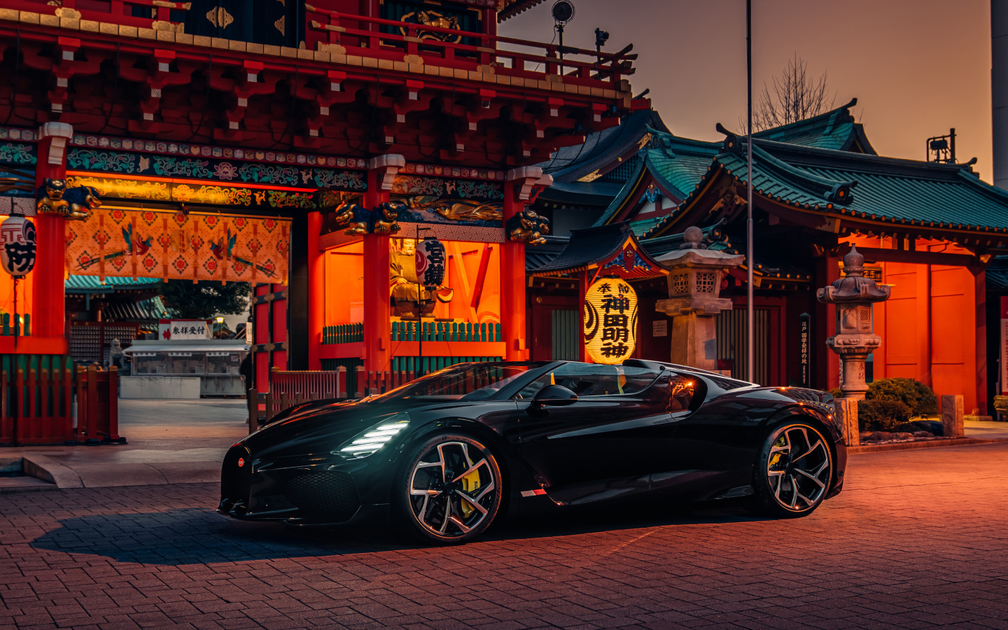 Черный спортивный автомобиль Bugatti W16 Mistral  у здания