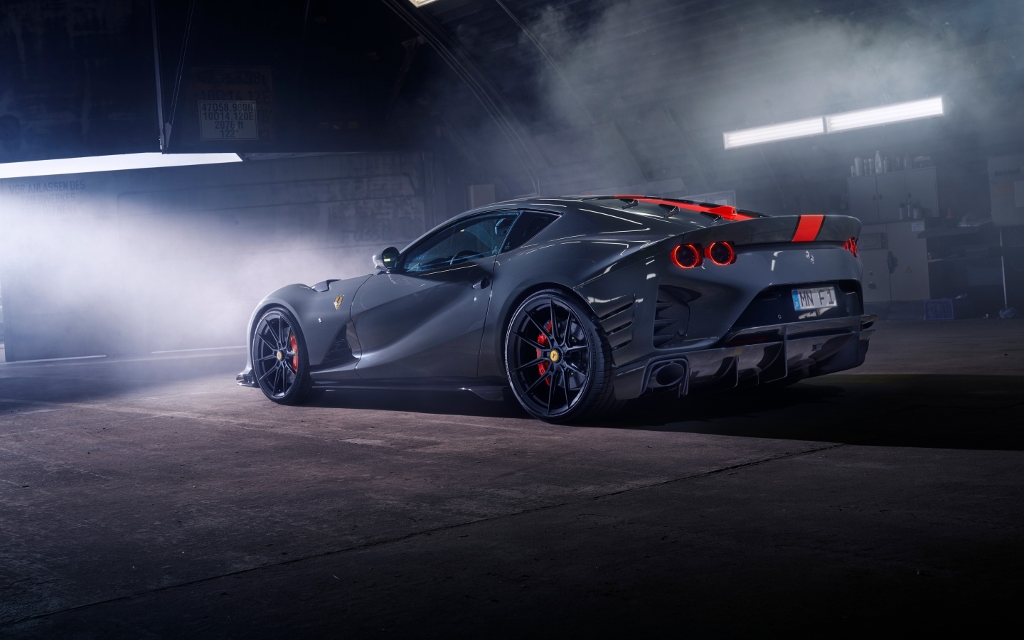 Серебристый спортивный автомобиль Ferrari 812 вид сзади