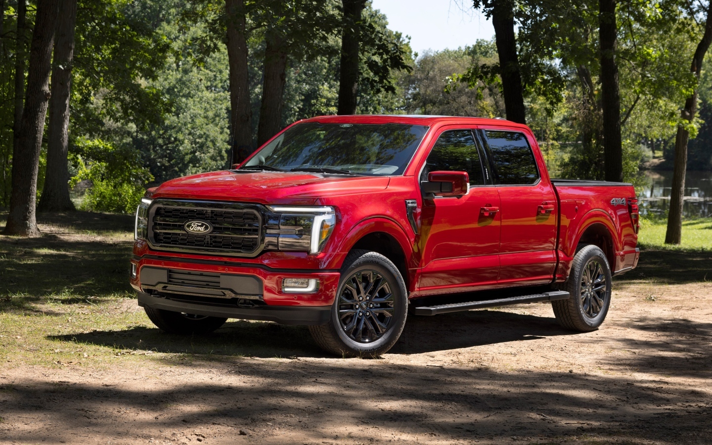 Большой красный Ford F-150 Lariat 2024 года в лесу