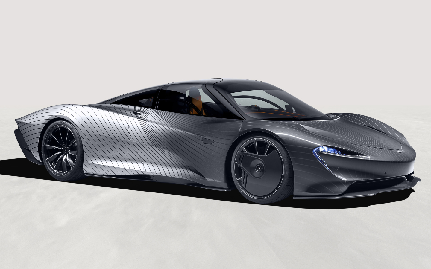 Серебристый McLaren MSO Speedtail Albert Hommage на сером фоне 