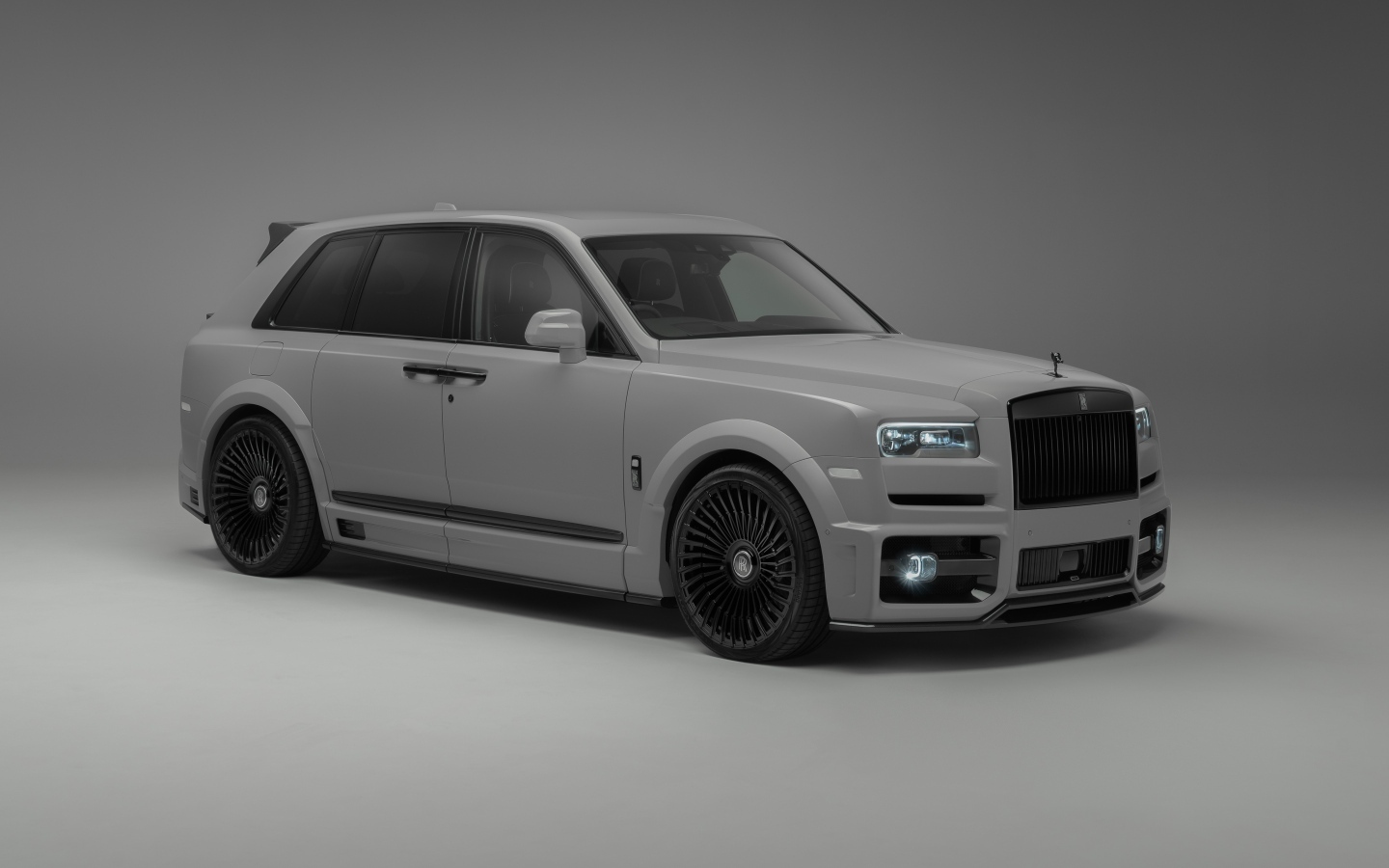 Автомобиль Rolls-Royce Cullinan на сером фоне
