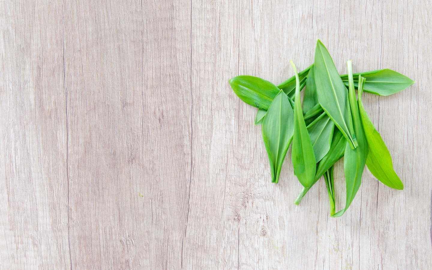 Пучок зеленых листьев на деревянной поверхности 