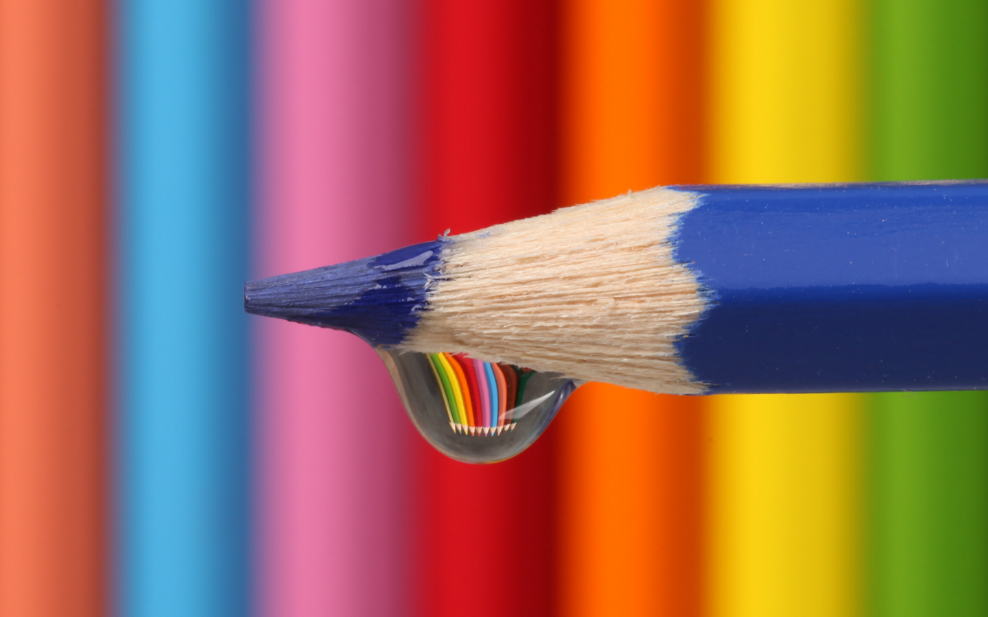 Капля воды стекает с синего карандаша