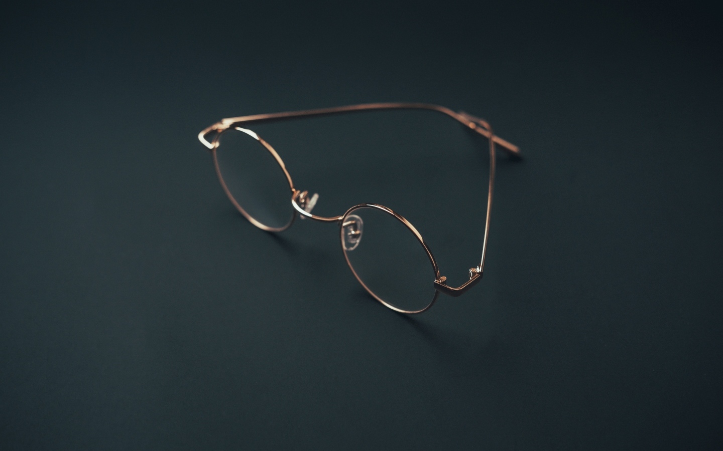 Очки лежат на серой поверхности