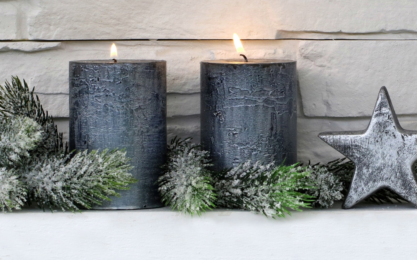 Две большие зажженные свечи у стены
