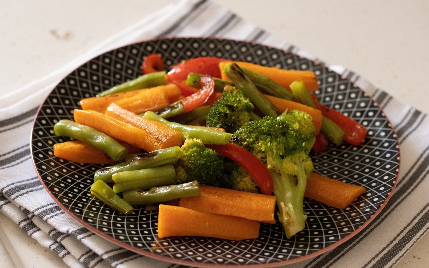 Запеченные овощи на красивой тарелке на столе