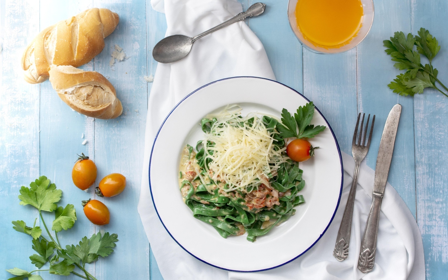 Зеленая лапша с сыром на столе с хлебом и зеленью