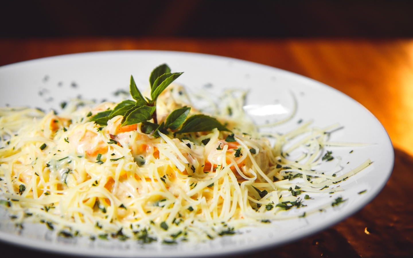 Спагетти с сыром и помидорами на белой тарелке