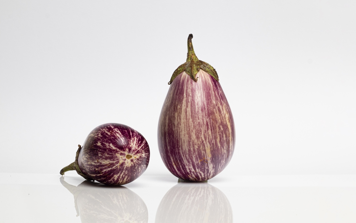 Два баклажана на сером фоне