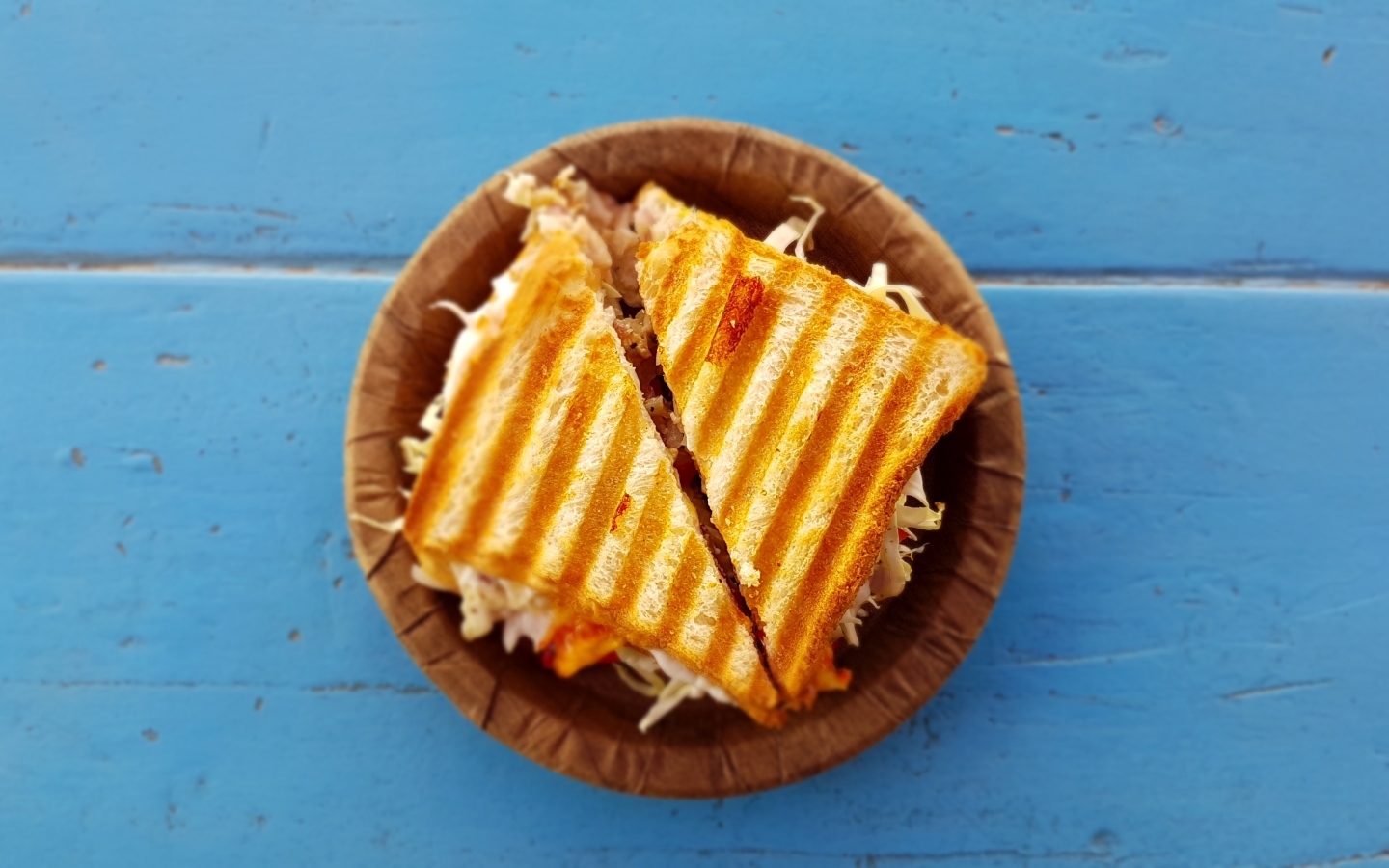 Два сэндвича на тарелке на голубом столе