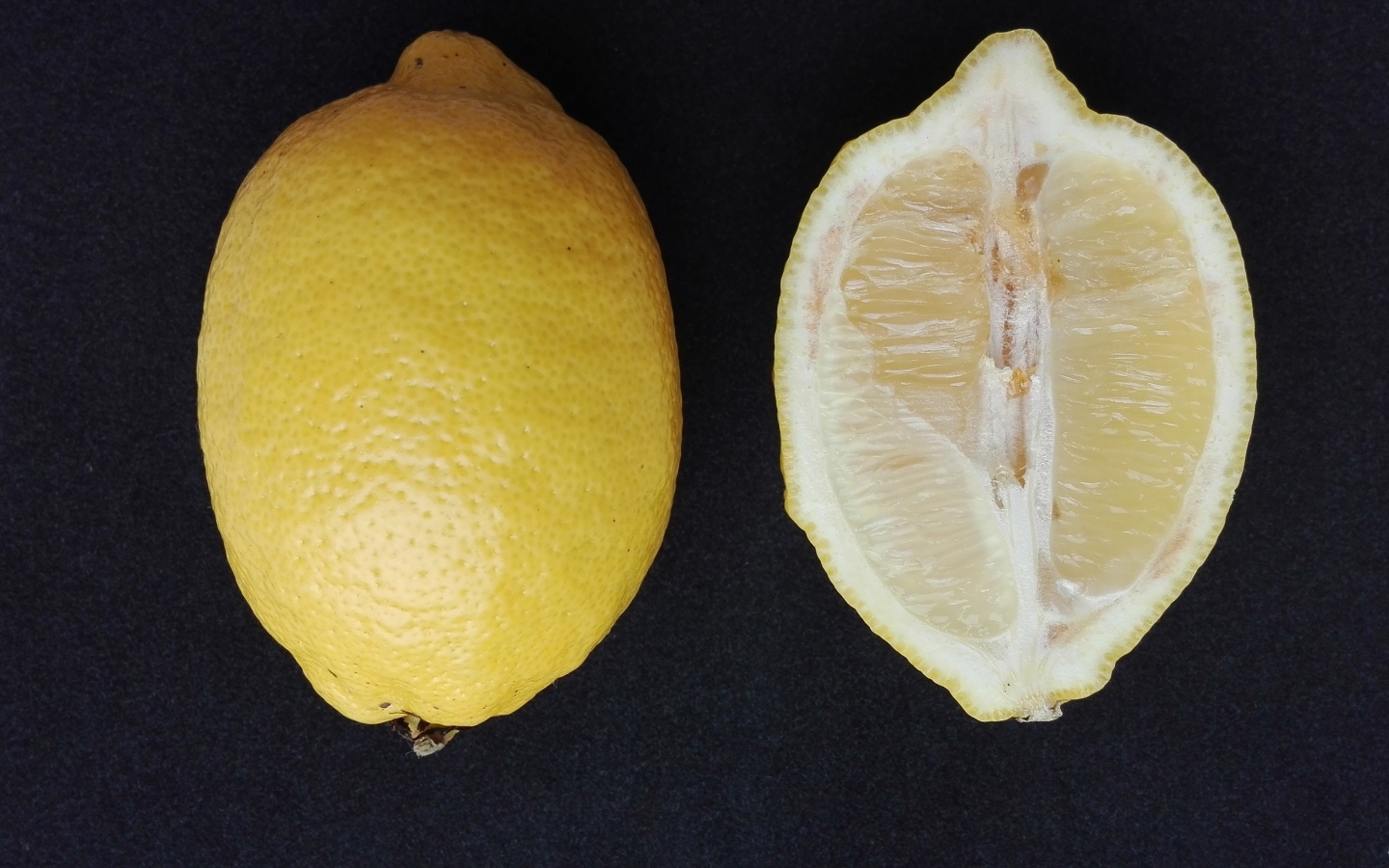 Разрезанный лимон на черном столе