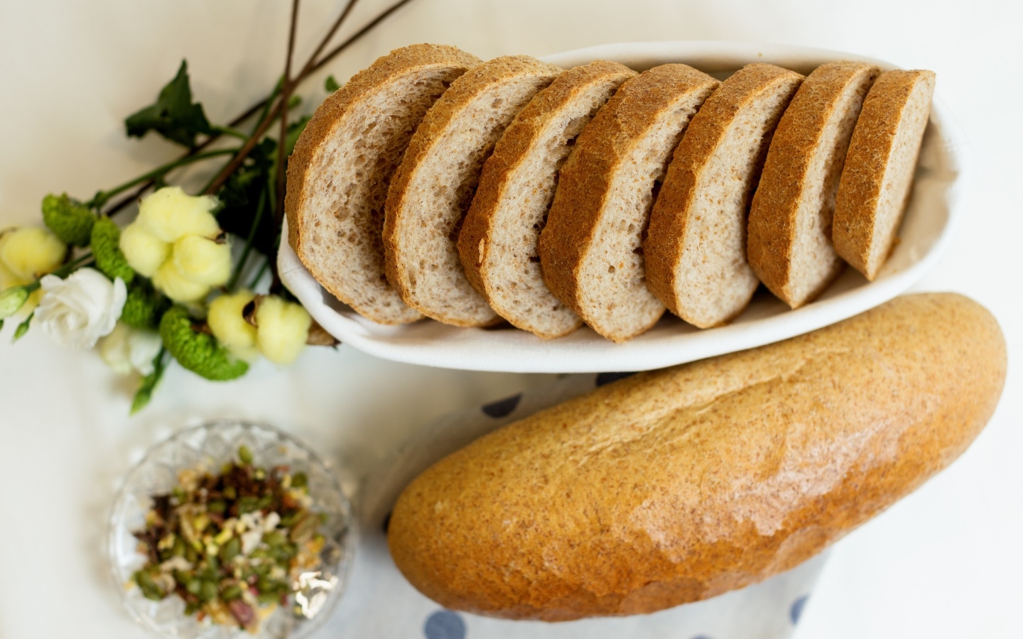 Батон нарезанный на столе с цветами