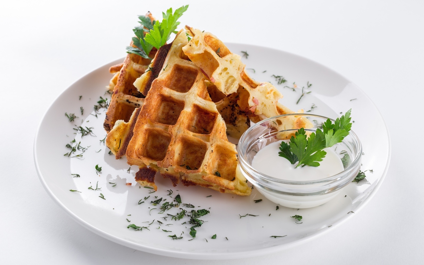 Вафли с соусом и зеленью на тарелке