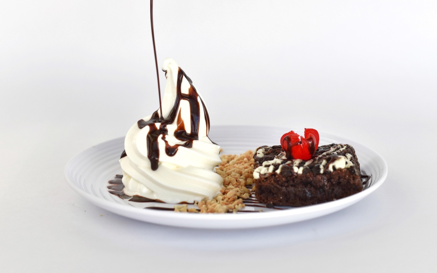 Пирожное со взбитыми сливками на тарелке на белом фоне