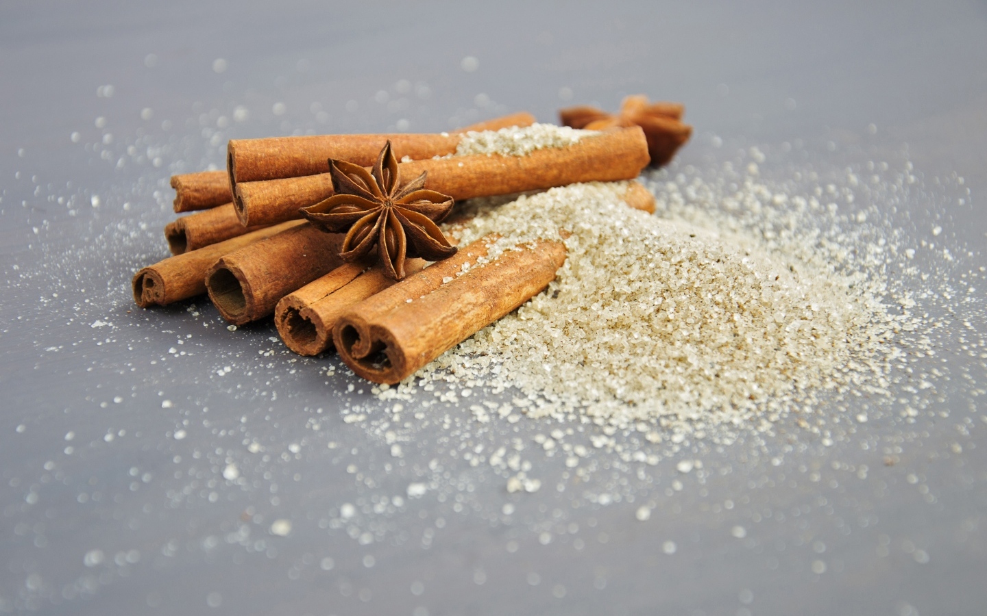 Корица с сахаром на сером фоне