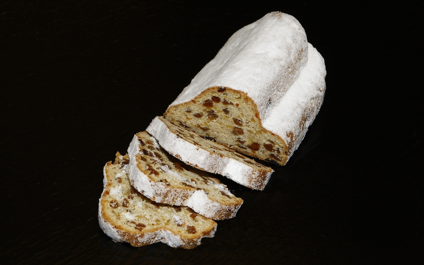 Кекс с изюмом и сахарной пудрой на черном фоне