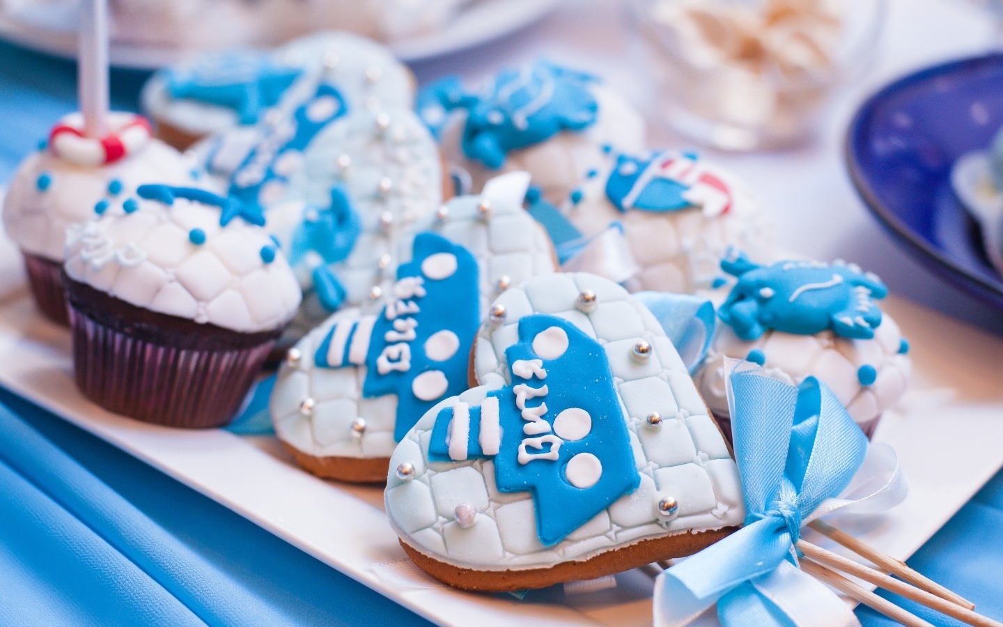 Пряники в форме сердца на палочке с кексами на столе