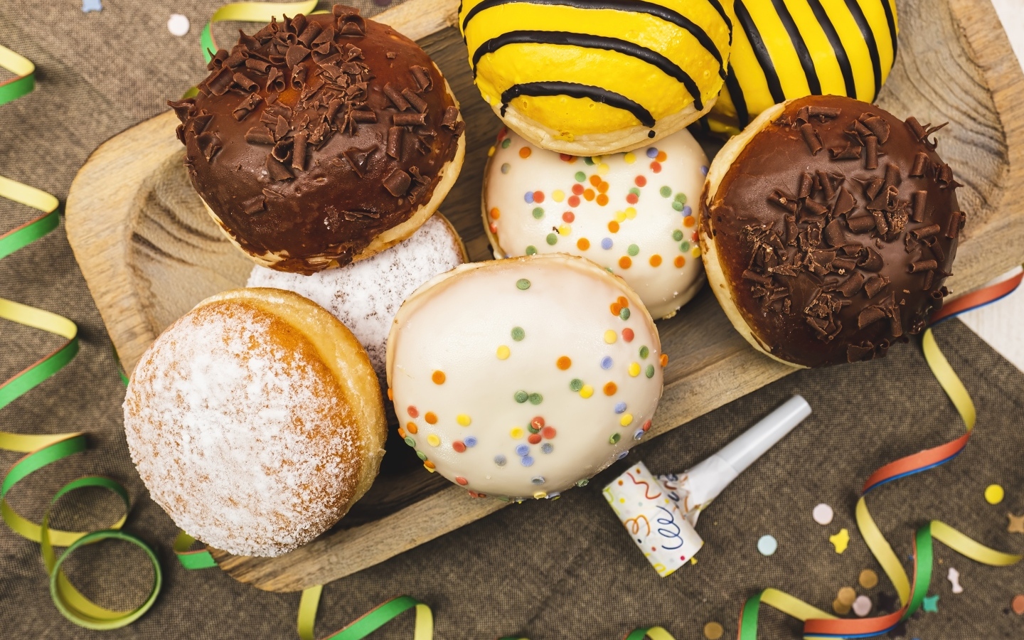 Много сладких пончиков в глазури на столе