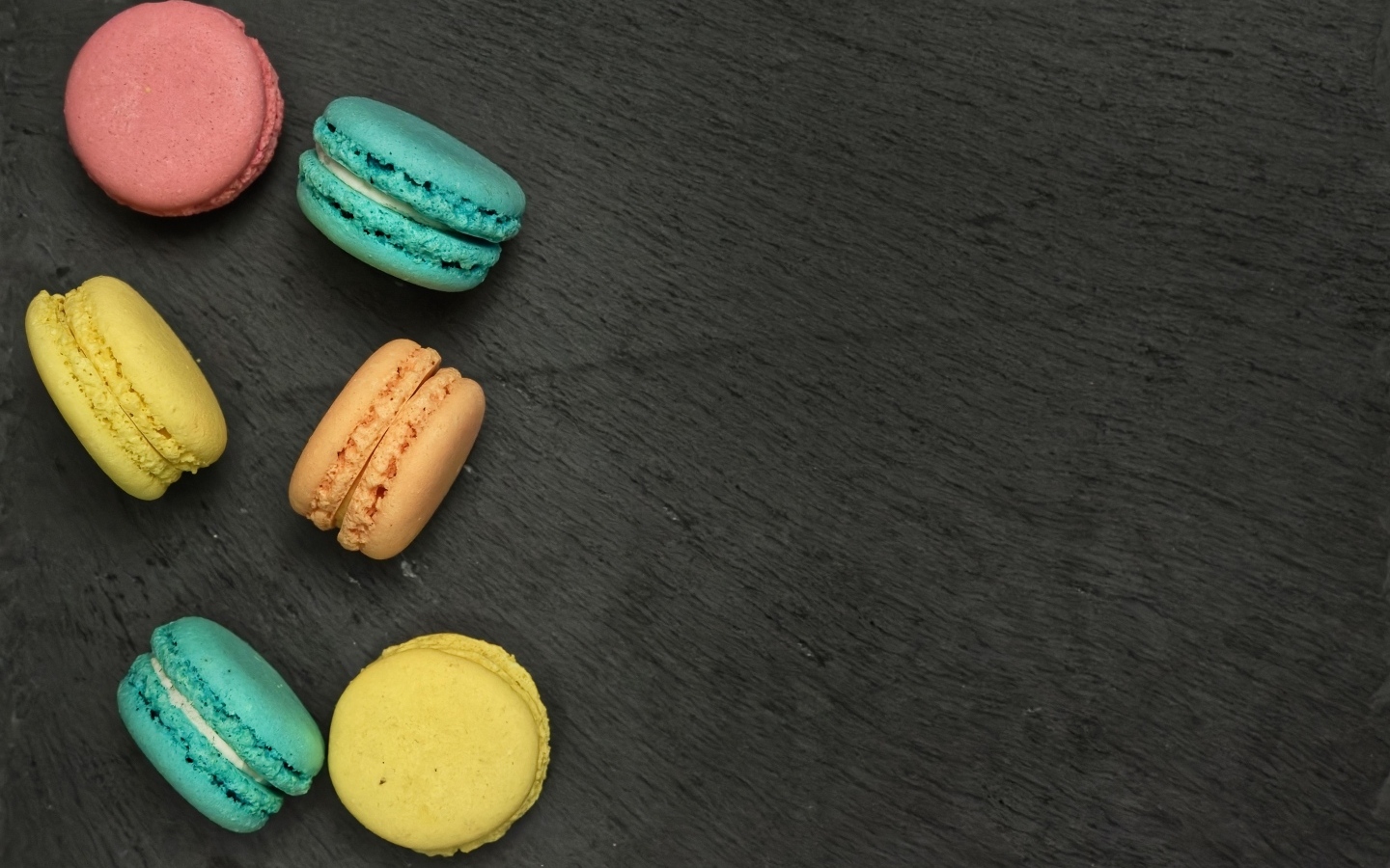 Разноцветный десерт макарон на сером столе