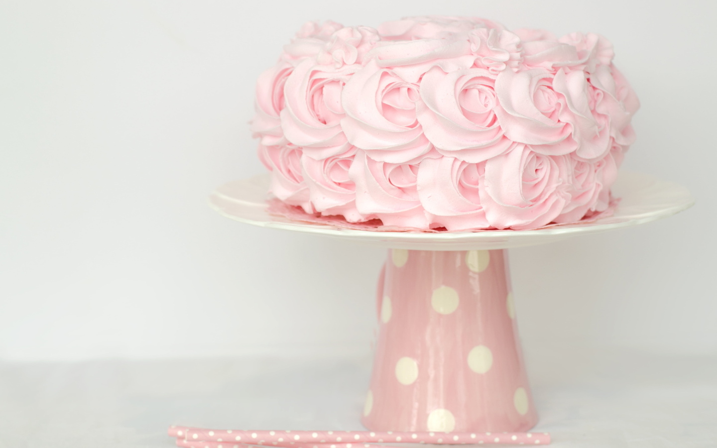 Розовый праздничный торт на столе